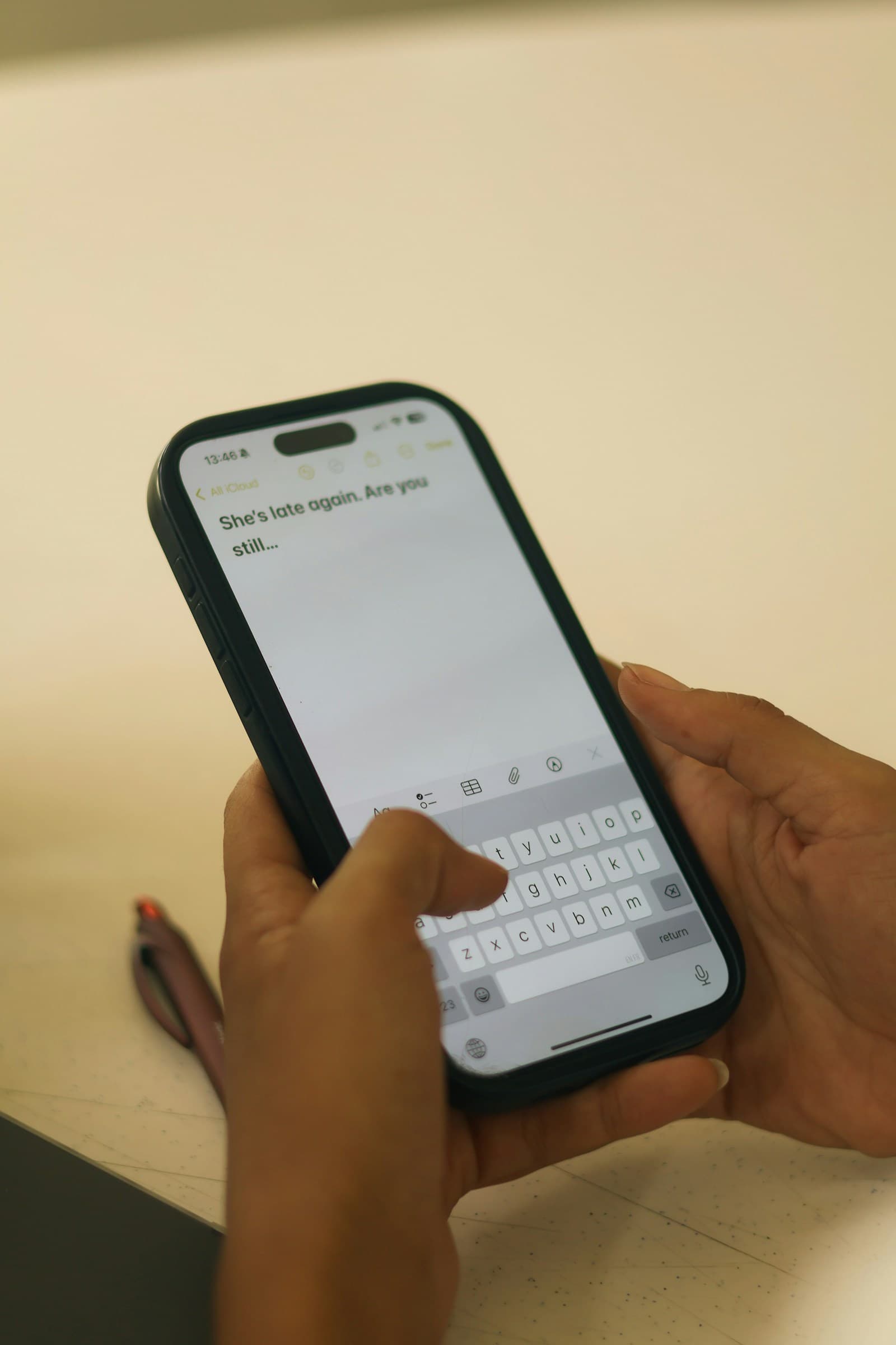 Hands typing a text message on a smartphone