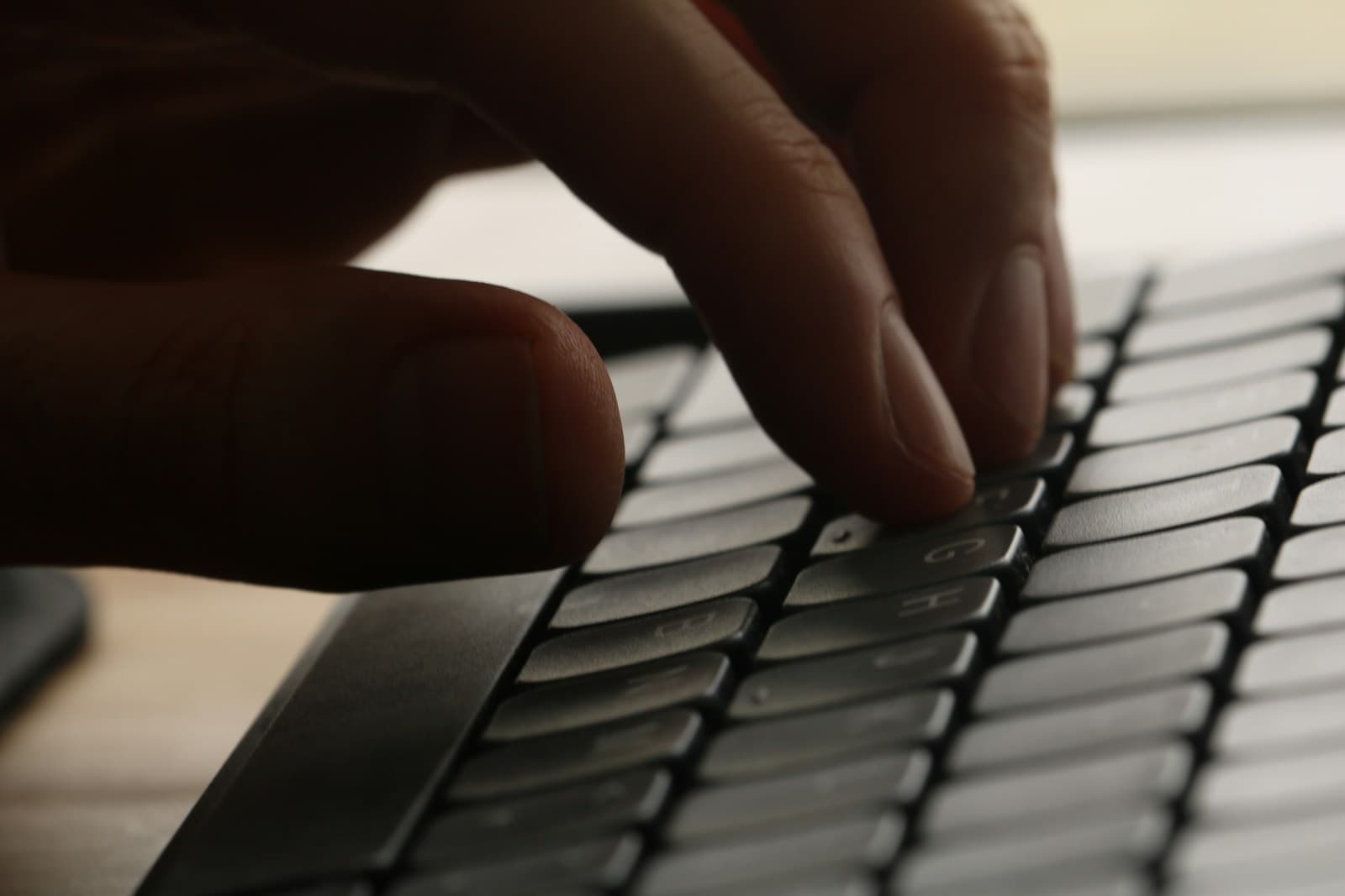 A hand typing on a laptop keyboard